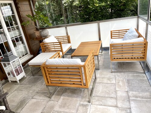 Wintergarten mit rustikalen Bodenplatten in zwei Grössen modular verlegt. Die neuen Holzmöbel passen wunderbar zum neuen Boden aus Feinsteinzeug.