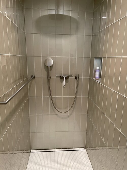 Elegante Dusche mit Glasplatten und modernen Armaturen. Die leicht beige Farbe hat einem Metallic Shimmer welcher schön glänzt.